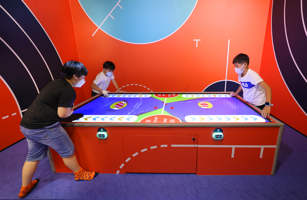 Sooper Yoo港島西大型室內遊樂場，家庭成員們在互動式氣墊球桌上進行科技體能競技，享受親子同樂時光。